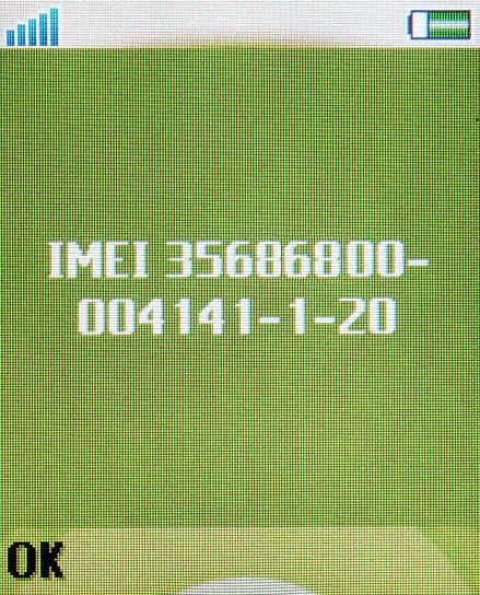 Pantalla verde de un celular de teclas que muestra en letras blancas la palabra IMEI seguida de un número largo, con el botón OK abajo