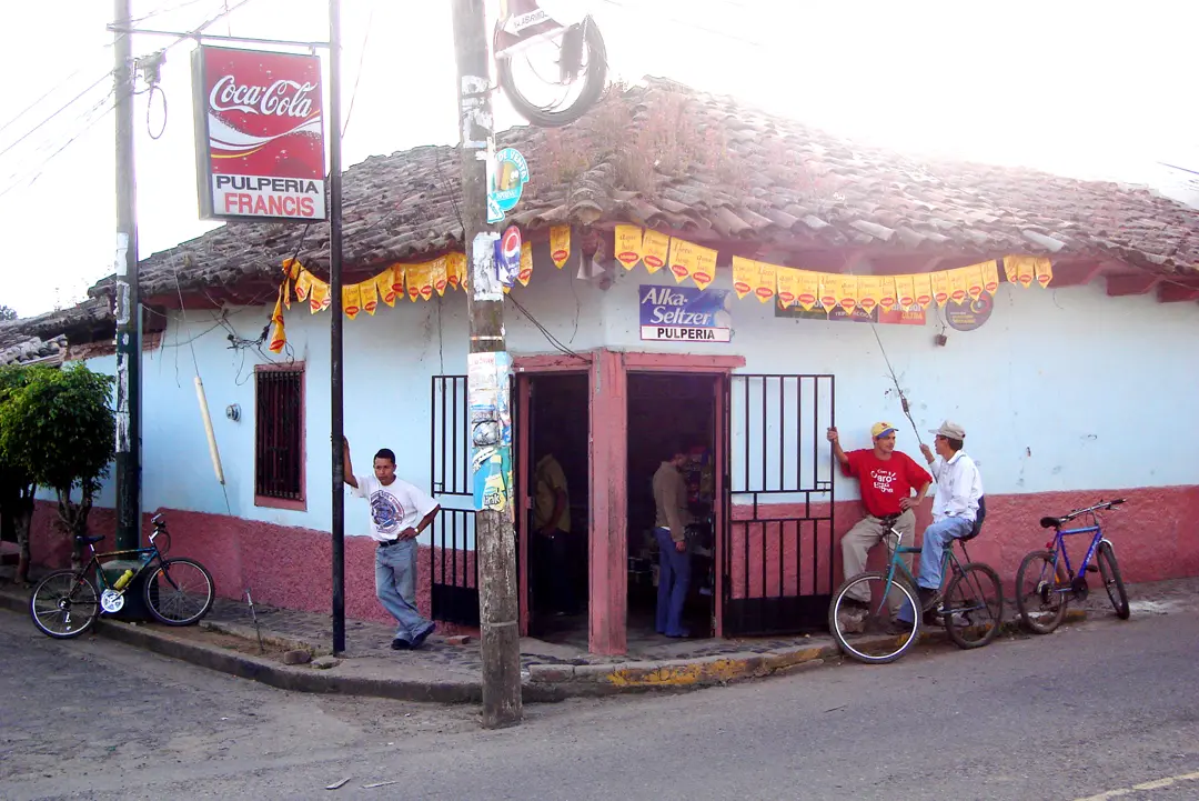 Pulpería de esquina en Valle de Ángeles, con techo de teja, paredes celestes y bicicletas afuera